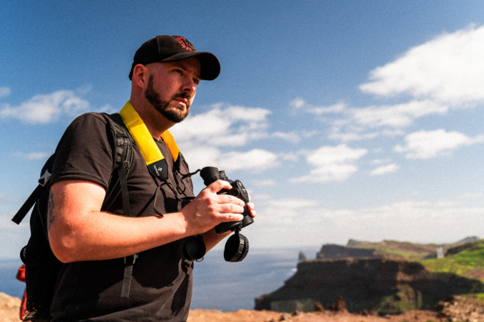 Christoph with binoculars at the coast of Madeira on a sunny day