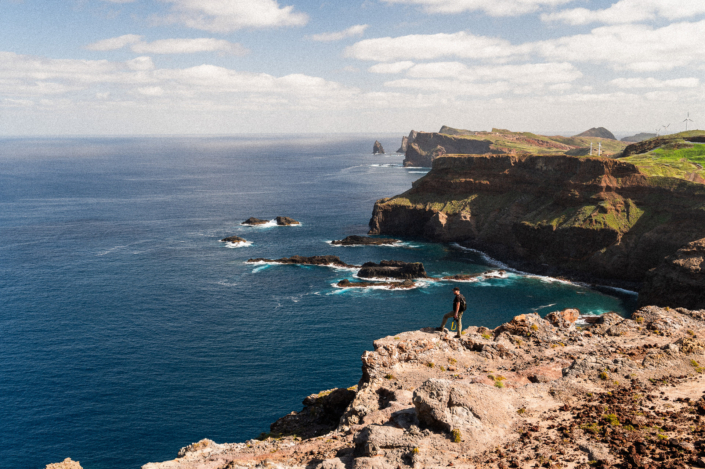 The coastal landscape of Madeira island and a man standing on a cliff, landscape format