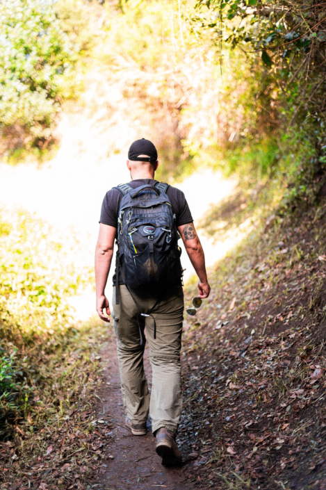 Christoph walking through the forest into sunshine