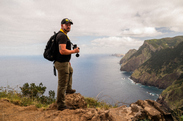 Christoph standing on a cliff on Madeira island with binoculars in his hands