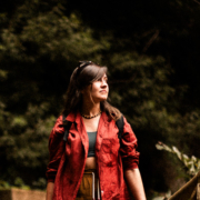 A girl in a red jacket walks through the forest