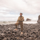 Female Digital Nomad on a pebble beach
